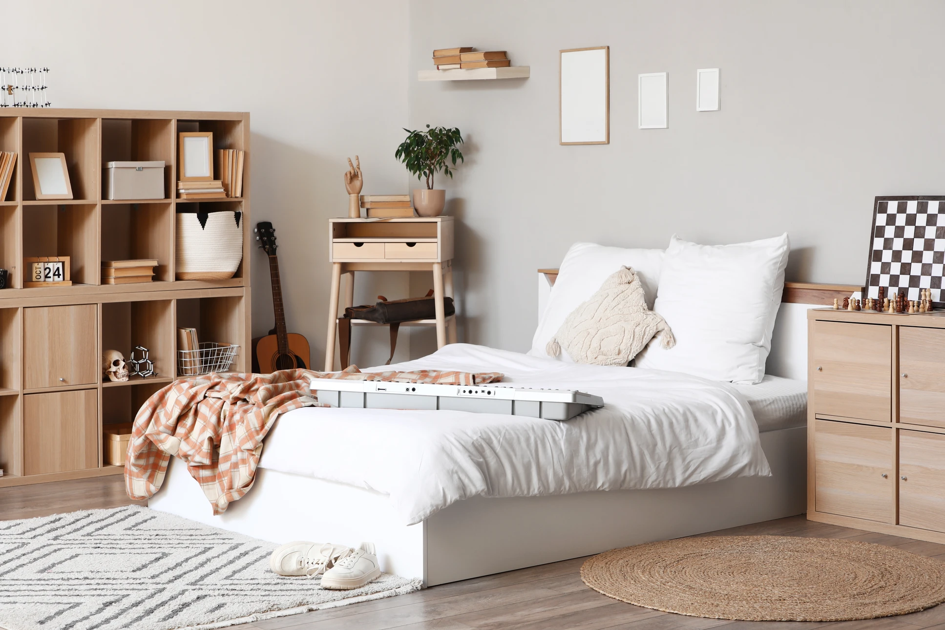 Artisan en jeans et ceinture porte-outils en cuir travaillant à l'intérieur, tenant une tablette numérique noire