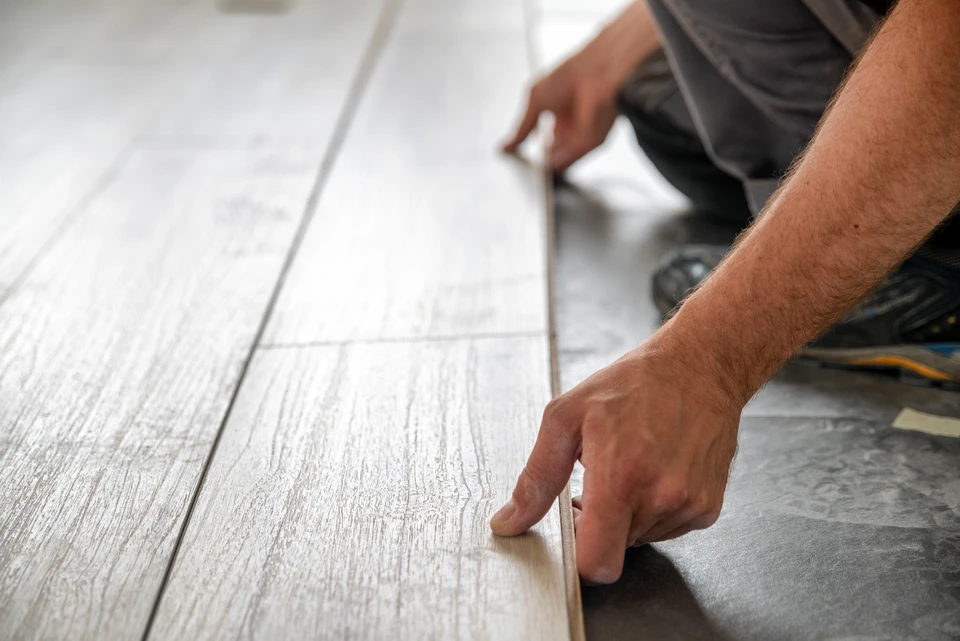 Un artisan professionnel installe un revêtement de sol dans un intérieur résidentiel moderne