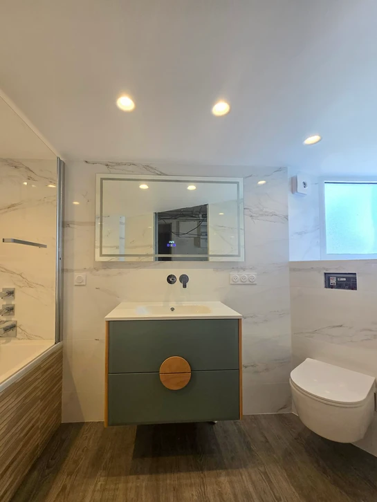 Chantier de rénovation intérieur avec ouvrier appliquant de l'enduit sur mur en briques apparentes