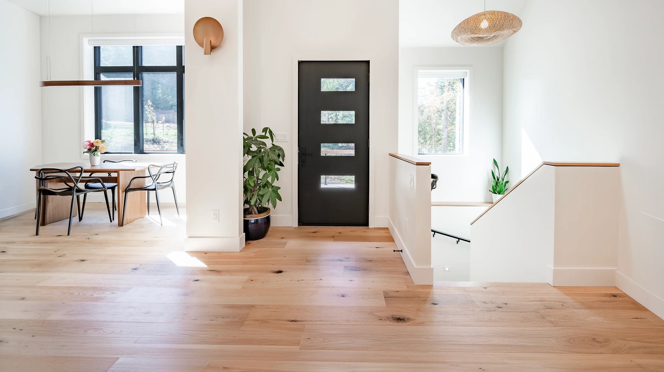 Homme agenouillé installant du parquet stratifié dans un intérieur résidentiel, positionnant une lame de revêtement de sol avec ses mains