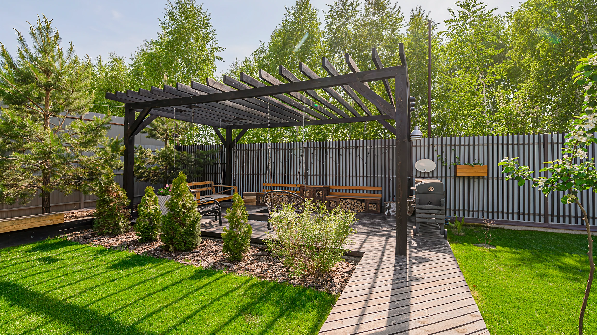 Terrasse extérieure couverte par pergola en bois avec éclairage intégré